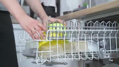洗碗机和脏盘子。 女人把盘子放好。